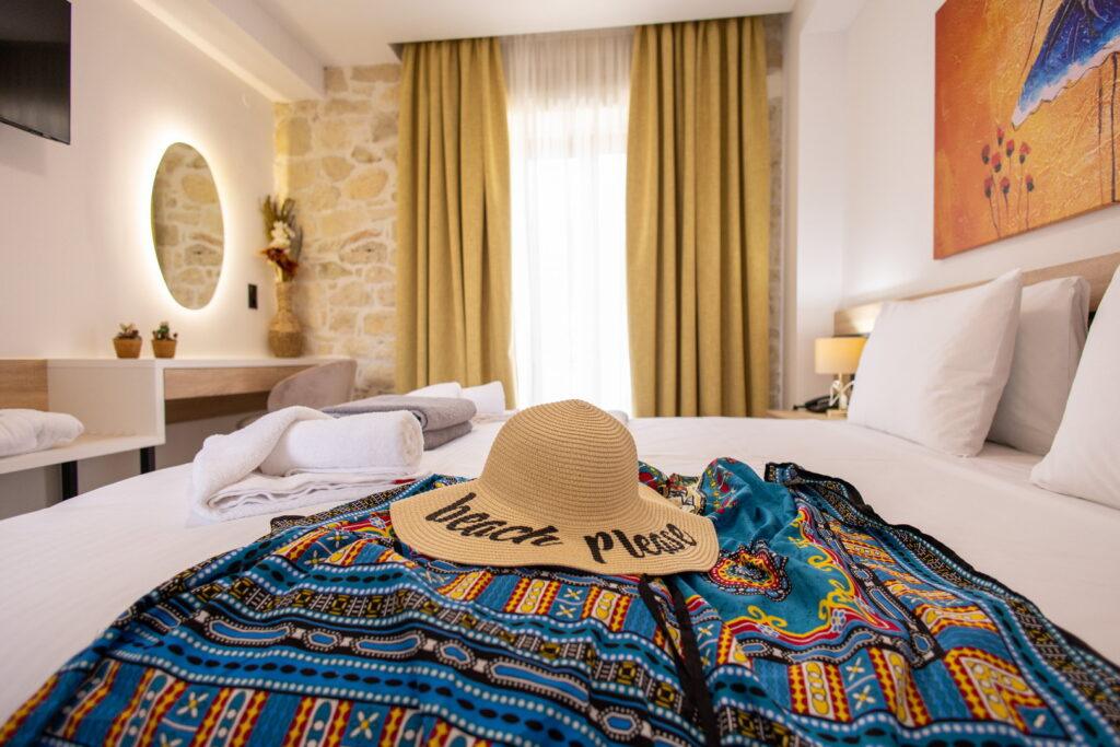 Bright double room at Sun & Sea Creta with cozy decor and beach accessories on the bed.